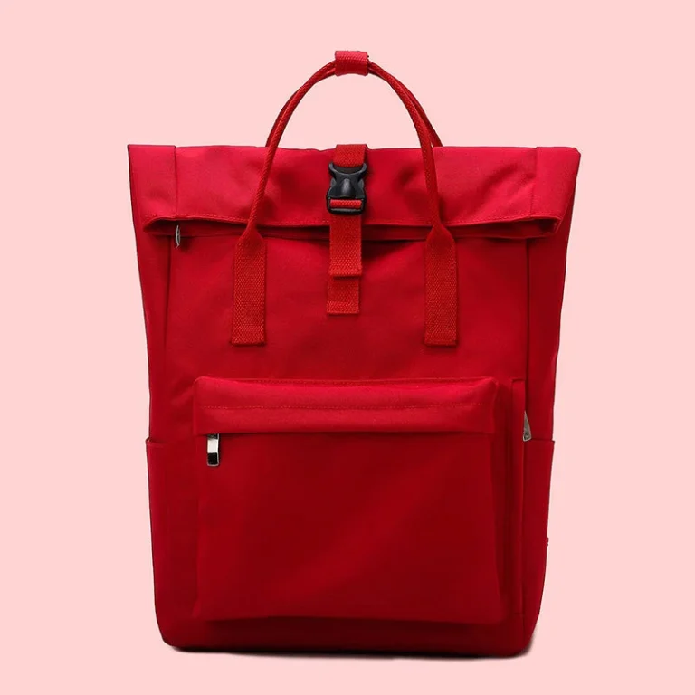 Roter Rucksack mit umgeschlagenem Oberteil und Fronttasche vor rosa Hintergrund