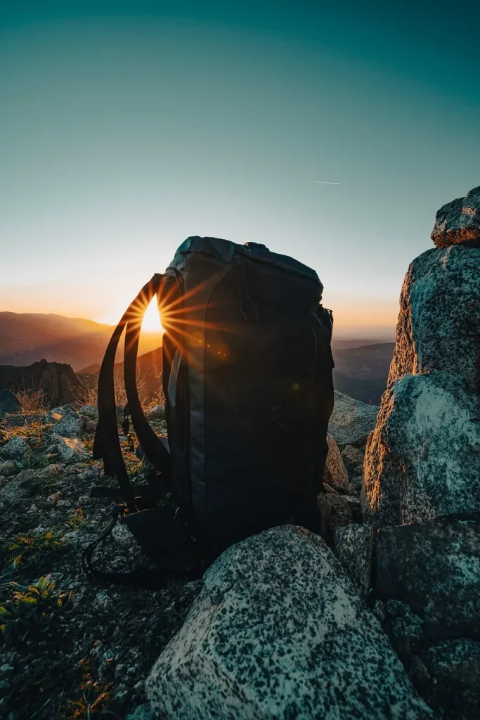 Schwarzer Rucksack auf Felsen im Abendlicht